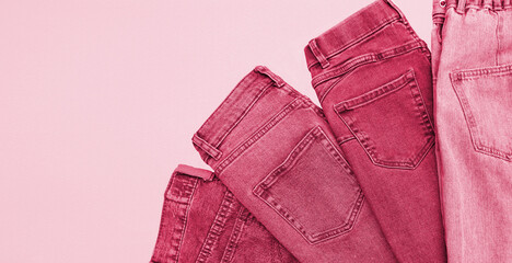 Lots of jeans pants in a stack. Denim background.