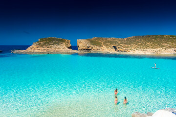 Comino, Malta, 22 May 2022:  Girls enjoying the crystal clear water of the Blue Lagoon