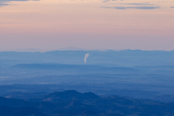Epic sunset over the canton of st. Gallen from the Säntis to Lake Constance with a large factory that develops smoke that is harmful to the climate.