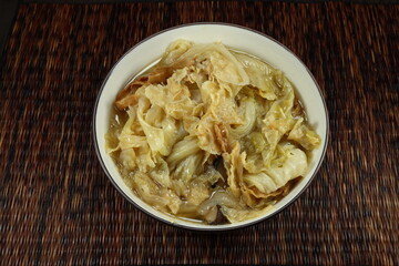Traditional boiled and steamed organic Chinese cabbage mixed with tofu sheet serving in the bowl. Famous vegetarian food with high fiber and vitamin.