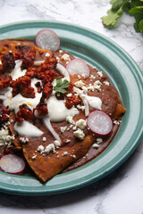 Mexican enfrijoladas with chorizo and fresh cheese
