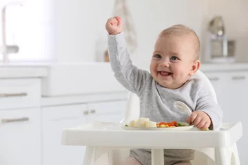 Fotobehang Cute little baby eating healthy food at home. Space for text © New Africa