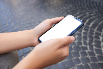Young woman with smartphone outdoors, closeup view