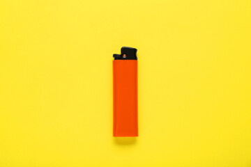 Stylish small pocket lighter on yellow background, top view