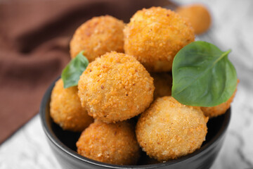 Delicious fried tofu balls with basil in bowl, closeup