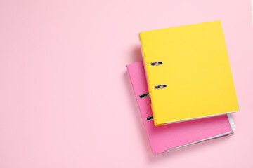 Office folders on pink background, flat lay. Space for text