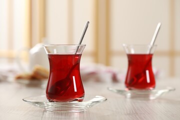 Glasses of traditional Turkish tea on white wooden table indoors. Space for text
