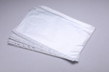 Punched pockets on light grey background. Document protection