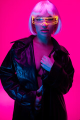 A girl in the cyberpunk style. Girl in neon with luminous glasses