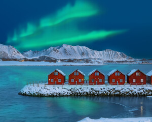 Amazing scenery wit traditional red wooden houses on the shore of Offersoystraumen fjord with...