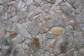 An abstract image of the texture on a grungy stone retaining wall. 