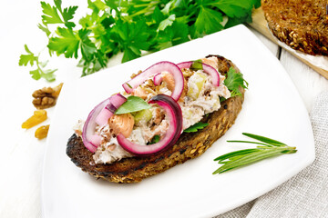 Bruschetta with fish and curd in plate on light board