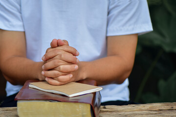 Christian life crisis prayer to god. Hands praying to god with the bible. believe in goodness.