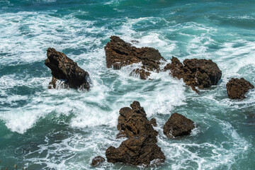Rocks waves and the blue sea