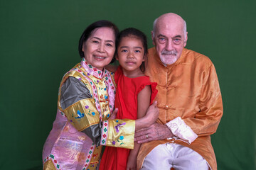 Grandpa and grandma in their Chinese traditional clothings, sharing their love with granddaughter during Chinese New Year 2547