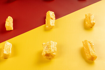 A portion of fried maniocs ( Mandiocas ) on a on a red and Yellow background, traditional brazilian food,