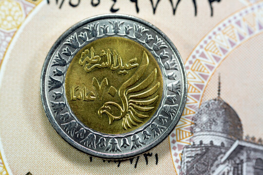 Obverse side of Egyptian 1 LE EGP One Egyptian pound coin on Egyptian banknote, Translation of Arabic (Police day 70 years) in the memorial of Egypt police day with a flying falcon