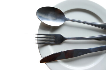 Fork, spoon, and knife in empty white plate with copy space isolated on white background closeup.
