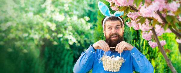 Funny man hunting easter eggs. Funny man having fun in park. Horizontal photo banner for website header design. Easter egg hunt concept.