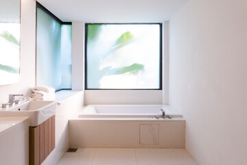 Naklejka na ściany i meble Natural white bathroom with banana tree view outside the window ready for relax body and mind in the bathtub