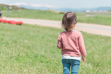 公園で遊ぶアジア人の子どもの後ろ姿（顔なし）
