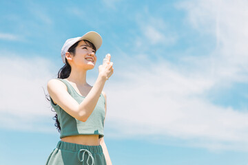 夏の運動前に制汗スプレー・UVケア・デオドラントケアをする日本人女性
