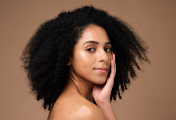 Portrait, beauty and afro with a model black woman in studio on a brown background for natural skincare. Face, cosmetics and hair with an attractive young female posing to promote cosmetics