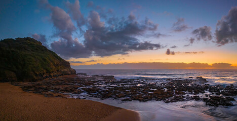 Dawn panorama with headland, beach and rock platform