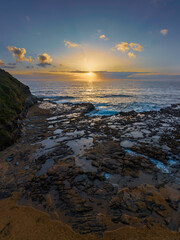 Obraz premium Sunrise over the ocean and rock platform