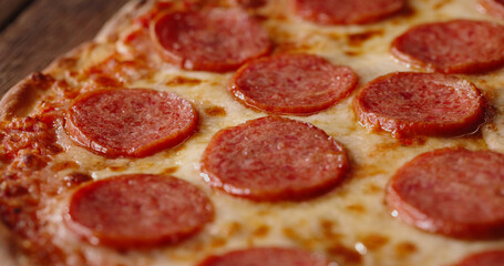 Close up shot of delicious pepperoni pizza with mozzarella cheese straight out of the oven. Tasty Italian pizza - food and drink 