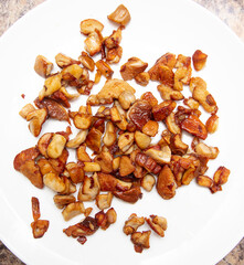 Fried mushrooms in a white plate on the table.