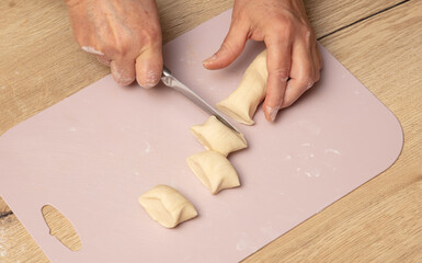 Cutting dough with a knife.