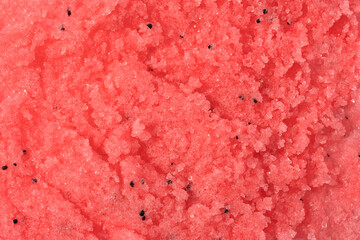 Sugar or salt body scrub texture. Pink red scrub - skin care product with fruit extract as cosmetic background with copy space. Macro photo