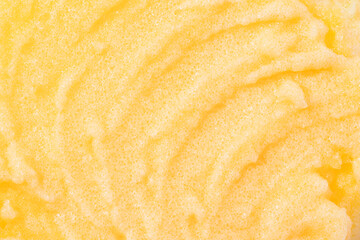 Sugar or salt body scrub texture. Yellow scrub - skin care product with fruit extract as cosmetic background with copy space. Macro photo