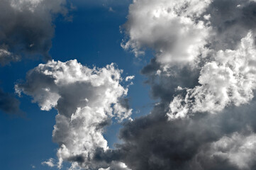 Aufsteigende, zerzauste Haufenwolken am blauem Himmel bei schönem Sommerwetter