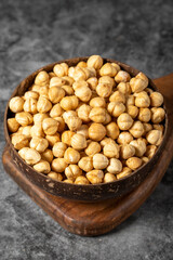Roasted hazelnut nuts on dark background. Fresh hazelnuts in a coconut bowl. Studio shoot. close up