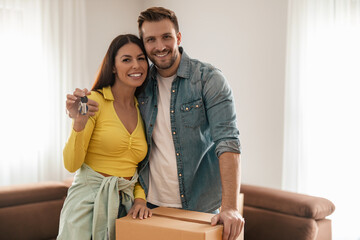 Smiling couple unpacking boxes in new home