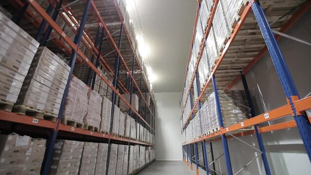 Modern logistics warehouse for the delivery and storage of goods. Shelves with cartons and boxes are distributed by nomenclature