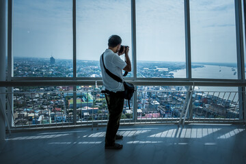 People are visiting and seeing the viewpoint on the top floor of Samut Prakan City Observatory....