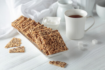 Crackers with sunflower seeds and flax seeds on a white table.