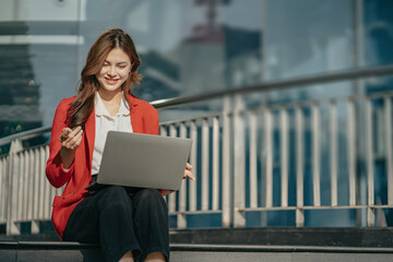 Young working woman video chatting on laptop computer smile while outdoors.