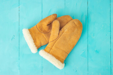 Suede leather mittens on blue wooden boards