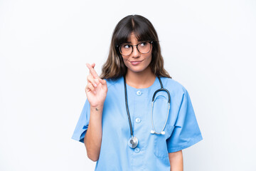 Young caucasian nurse woman isolated on white background with fingers crossing and wishing the best