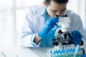 Lab assistant, a medical scientist, a chemistry researcher holds a glass tube through the blood sample, does a chemical experiment and examines a patient's blood sample. Medicine and research concept.