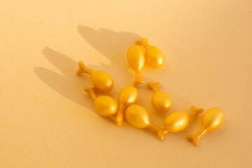 capsules with a cream or serum for face treatment on beige background. Single dose capsules for beauty care. collagen peptides or hyaluronic acid. Skin care background in minimal style.