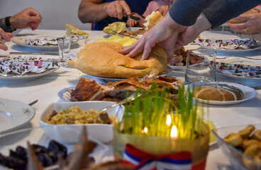 Orthodox Christmas table. Christmas wheat and lighted candles. Flag of Republika Srpska. People eating Christmas breakfast.