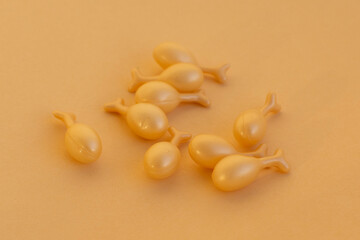 capsules with a cream or serum for face treatment on beige background. Single dose capsules for beauty care. collagen peptides or hyaluronic acid. Skin care background in minimal style.