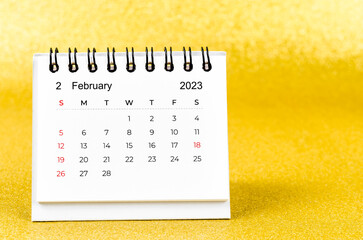 The February 2023 Monthly desk calendar for 2023 year on golden color background.