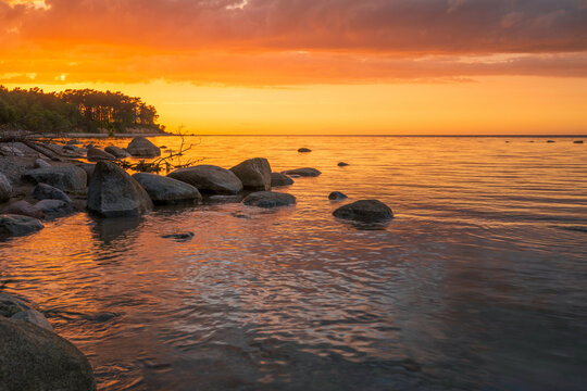 Wonderful orange sunset on the rocky coast of the sea