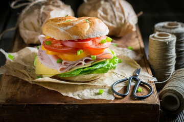 Healthy take away sandwich with ham, tomatoes and cheese.